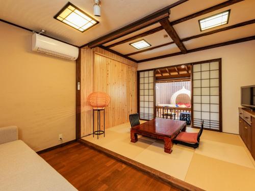 a room with a bed and a table in it at AsoTsuruya in Aso
