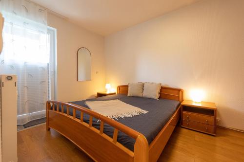 a bedroom with a wooden bed and a window at ST33-22 - Appartement Typ D in Dorum Neufeld