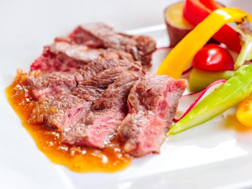 a piece of meat and vegetables on a white plate at AsoTsuruya in Aso