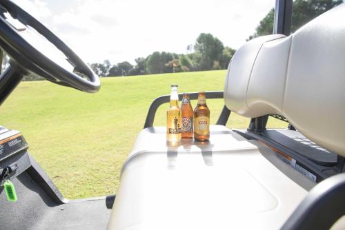 tres botellas de cerveza sentadas en una mesa en un vehículo en Corowa Golf Club Motel, en Corowa