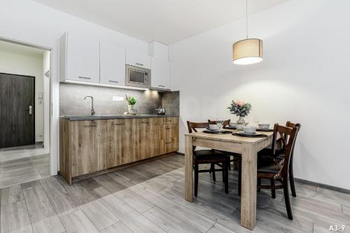 a kitchen and dining room with a table and chairs at KORZO Lipno in Lipno nad Vltavou