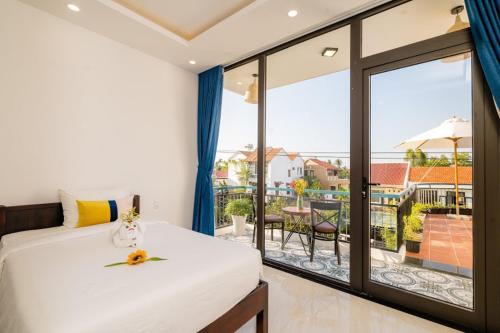 a bedroom with a bed and a view of a balcony at 5 Coconut Villa in Hoi An