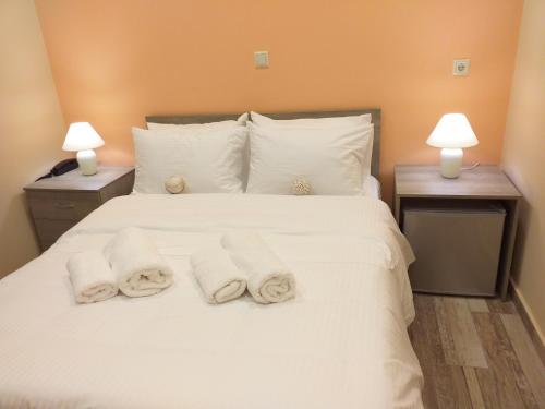 a bedroom with a white bed with towels on it at CityZen Rooms Chios in Chios
