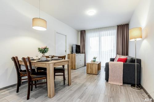 a living room with a dining room table and a couch at KORZO Lipno in Lipno nad Vltavou
