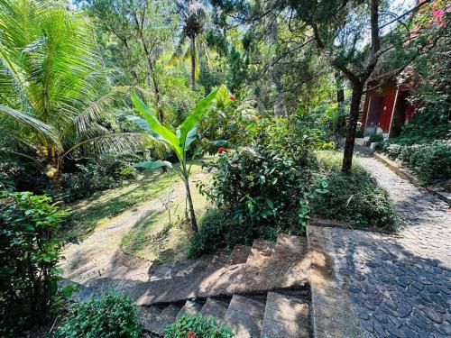 a path in a garden with trees and plants at Pondok Wisata Grya Sari in Banjar