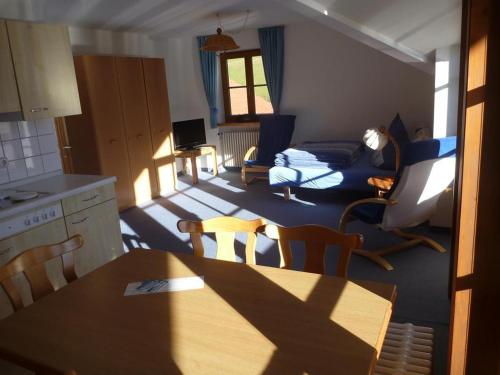 eine Küche und ein Wohnzimmer mit einem Tisch und Stühlen in der Unterkunft Ferienwohnung Stoll Helga in Burgberg