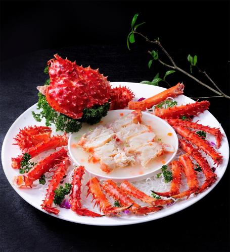 a plate of food with carrots and broccoli on a table at Peony Hotel in Dubai