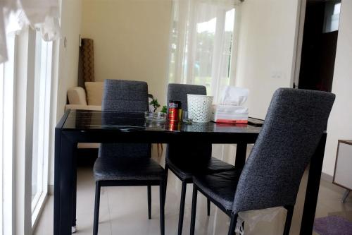 a black dining room table with four chairs at Privat Homestay Malang Oz HK 39 in Dau