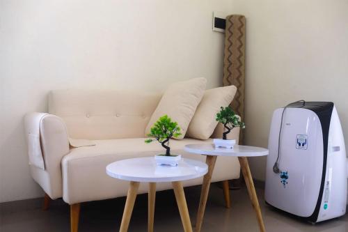 a living room with a couch and a refrigerator at Privat Homestay Malang Oz HK 39 in Dau