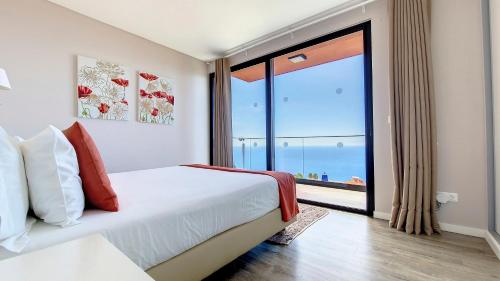 a bedroom with a bed and a large window at Elísio do Mar by LovelyStay in Prazeres