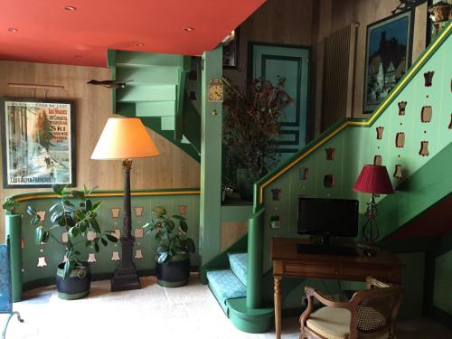 a living room with a staircase with a couch and a lamp at Le Manoir Au Lac in Gérardmer