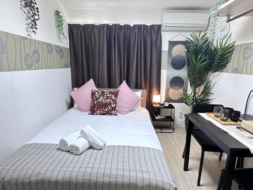 a bedroom with a bed and a desk with towels on it at 清水三年坂 Home in Kyoto in Kyoto