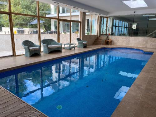 a large swimming pool with chairs in a building at Portelet Bay in St Brelade