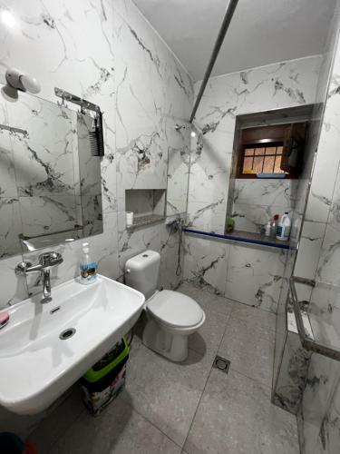 biała łazienka z umywalką i toaletą w obiekcie BOULEVARD Apartment w Tiranie