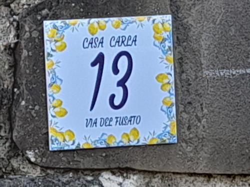 a sign on the side of a stone wall at Via del Fusato 13 Casa Carla in Chiusi della Verna