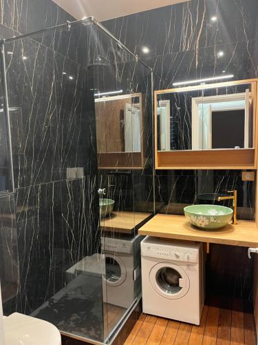 a bathroom with a washer and dryer in it at Le Royal XIX Dinard vue mer luxe in Dinard