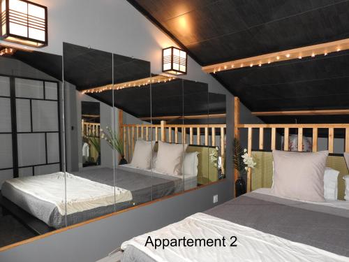 dwa łóżka w pokoju z oświetleniem na suficie w obiekcie Love Room Narbonne w mieście Narbona