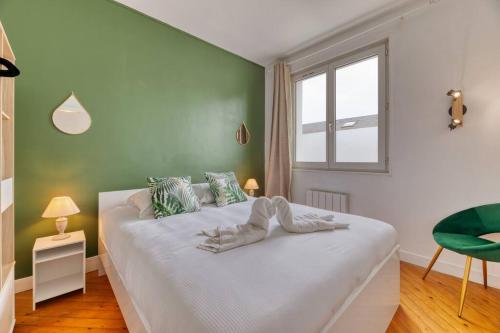 ein Schlafzimmer mit einem weißen Bett und einer grünen Wand in der Unterkunft Saint Maur * F2* beau logement entier in Rouen