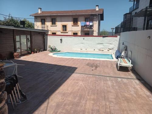 einen Hinterhof mit einem Pool und einem Haus in der Unterkunft Preciosa casa bi-familiar al lado de Donosti. in Irún
