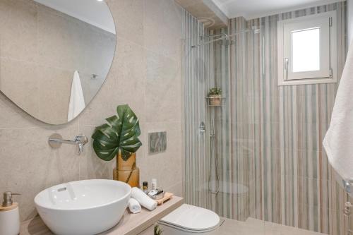 a bathroom with a sink and a toilet and a mirror at Elianes Villas in Anomeriá