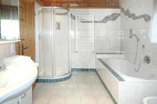 a bathroom with a shower and a tub and a toilet at Apart Resort Rabl in Westendorf