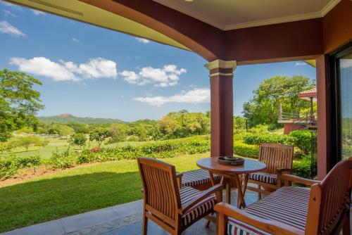 un patio con sillas y una mesa con vistas a un patio en Bougainvillea 5102 Luxury Apartment - Reserva Conchal en Playa Conchal