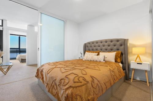 a bedroom with a large bed and a glass wall at Prestige 2bd Apartment Gym/Pool in Adelaide