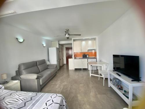 ein Wohnzimmer mit einem Sofa und einem Flachbild-TV in der Unterkunft Estudio Rodri By Solymar Holiday in Torre del Mar