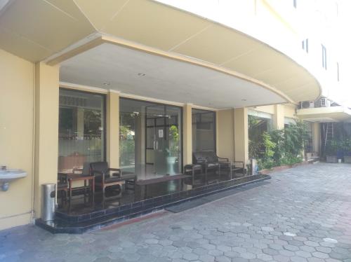 a building with chairs and tables on a patio at Shafira Hotel Yogyakarta in Ngabean