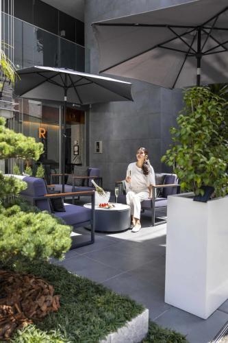 a woman sitting in a chair under an umbrella at Kamo Residences by Reflections in Kyoto