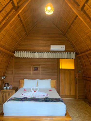 una camera da letto con letto in una camera in legno di Kubu Padi Wooden House a Pemuteran
