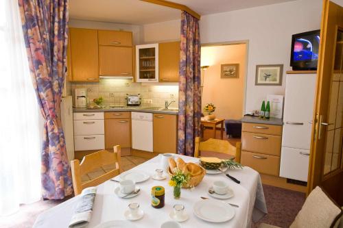 a kitchen with a table with a white table cloth at Sonnhof-Christianhof, Appartement in Bad Hofgastein