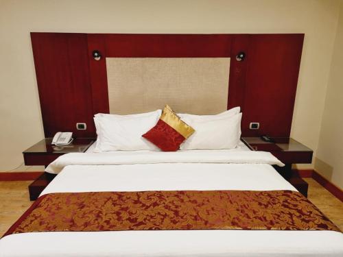 a hotel room with two beds with pillows at رؤوم ان للشقق الفندقية- Raoum Inn Hotel Apartments-Sakaka in Sakakah