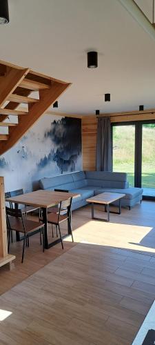 Domki Krynica في كرينيتسا زدروي: غرفة مع طاولات وكراسي في مبنى