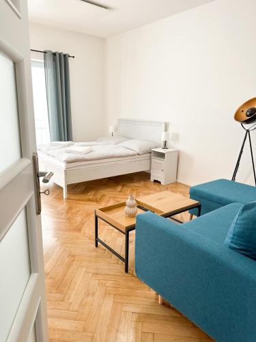 een woonkamer met een blauwe bank en een bed bij Jen tak spolu - apartmán Znojmo in Znojmo