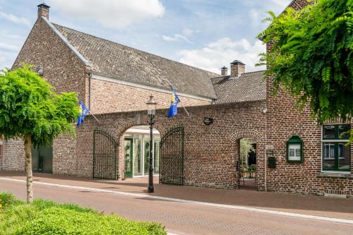 a brick building with an archway on a street at Hoeve de Bongerd in Beesel