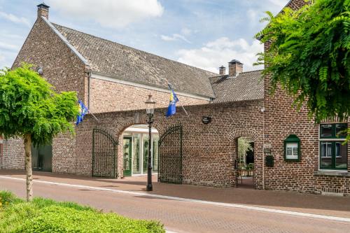 un edificio de ladrillo con un arco en una calle en Hoeve de Bongerd, en Beesel