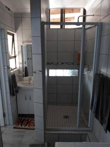 a bathroom with a shower with a glass door at Paradise Lake flats in Sedgefield
