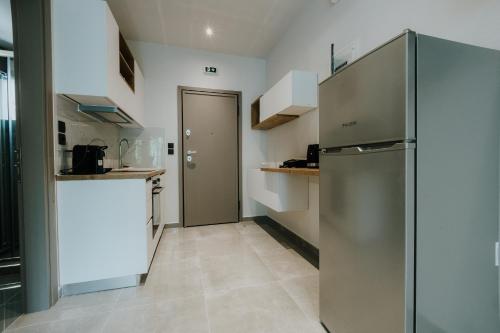 a kitchen with a refrigerator and a counter at Pearl Apartel in Volos
