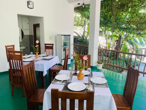 a dining room with tables and chairs and a balcony at Misty Elegance - Ella. in Ella