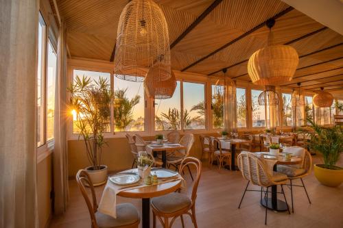un restaurant avec des tables, des chaises et des fenêtres dans l'établissement New President Hotel Cairo, au Caire