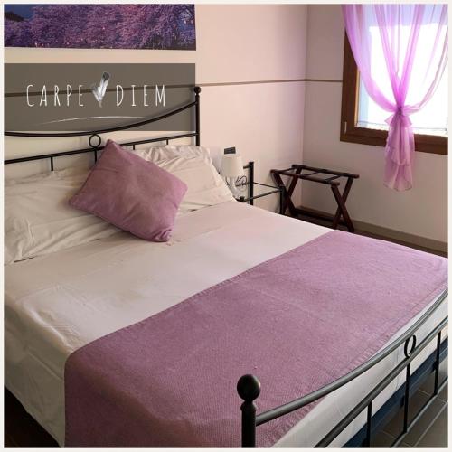 a bedroom with a large bed with a purple blanket at Carpe Diem Countryhouse in Cesarolo