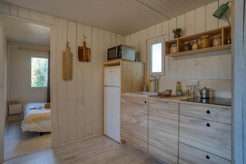 a kitchen with a refrigerator and a microwave at Slow Village Ile de Ré in Saint-Martin-de-Ré