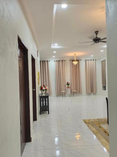 a large room with a white tile floor and a ceiling at Inara Homestay Besut in Jertih
