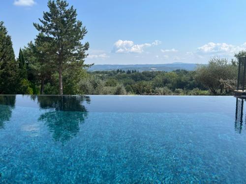 a large pool of water with trees in the background at Poggio dell' orso in Cetona