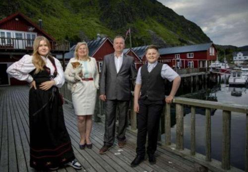 a group of people standing on a wooden bridge at Kræmmervika Havn in Ballstad