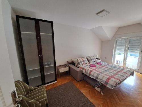 una camera con un letto e una sedia di L&M 2 Apartman a Bijeljina