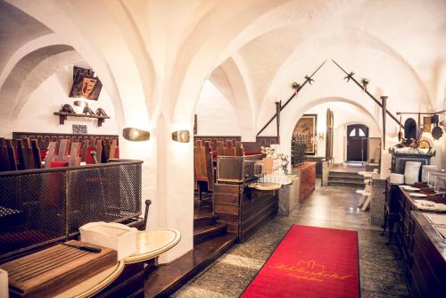 a restaurant with a red rug in a room at Schlosshotel Neufahrn in Neufahrn in Niederbayern