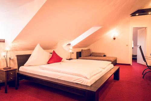 een slaapkamer met een groot bed op zolder bij Schlosshotel Neufahrn in Neufahrn in Niederbayern