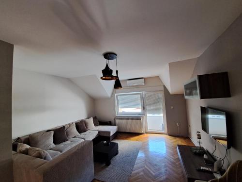 uma sala de estar com um sofá e uma televisão em L&M 2 Apartman em Bijeljina